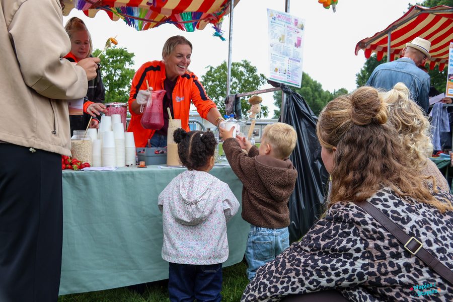 Medewerker van Spurd schenkt verse smoothies uit voor twee kinderen