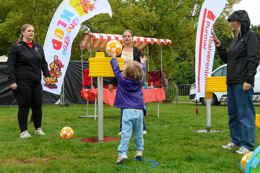 Kind gooit een bal naar de korf bij de korfbalclinic