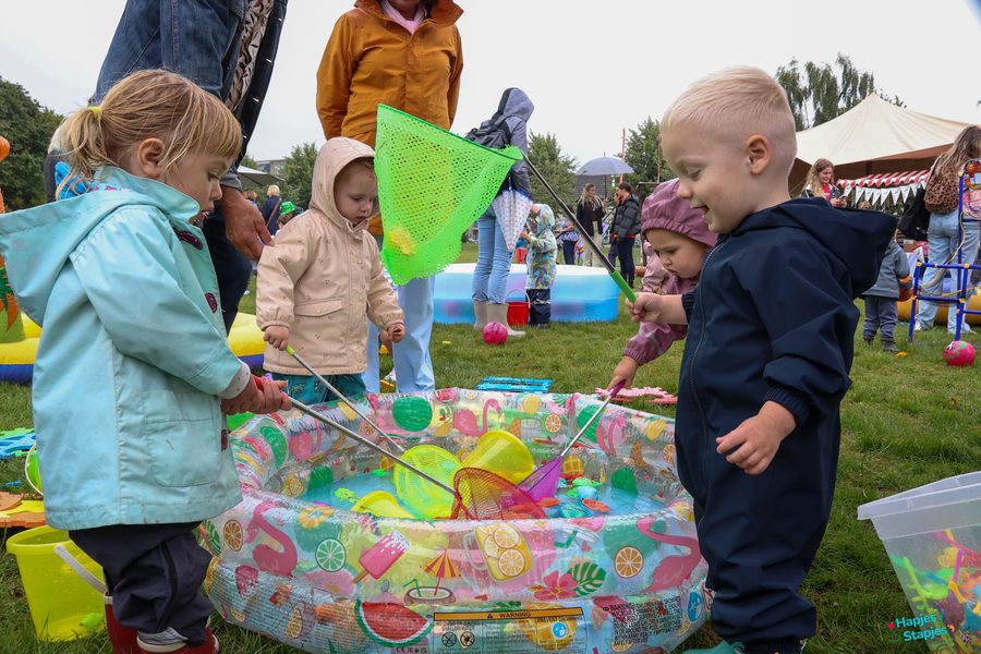Peuters vissen met schepnetjes speelgoed uit een opblaasbadje