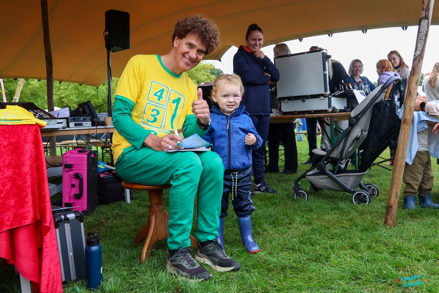 Dirk Scheele deelt handtekeningen uit, een peuter steekt zijn duim op