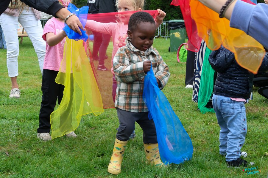 Kinderen dansen met kleurige doeken tijdens de dansclinic